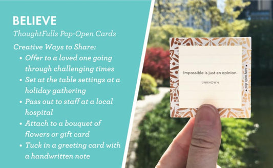 A hand holds a small Thoughtful Cards pop-open card with a warm patterned border and the quote 'Impossible is just an opinion.' The left side of the image has a teal panel with white text describing the card and creative ways to share it, with a blurred garden background on the right.