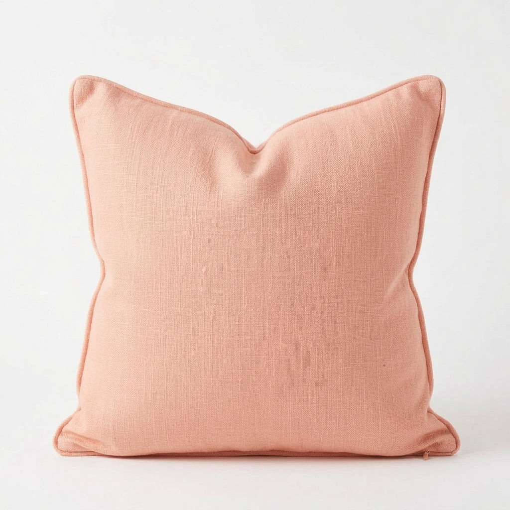 A square decorative throw pillow in a dusty terracotta or muted coral pink color, shown against a plain white background.