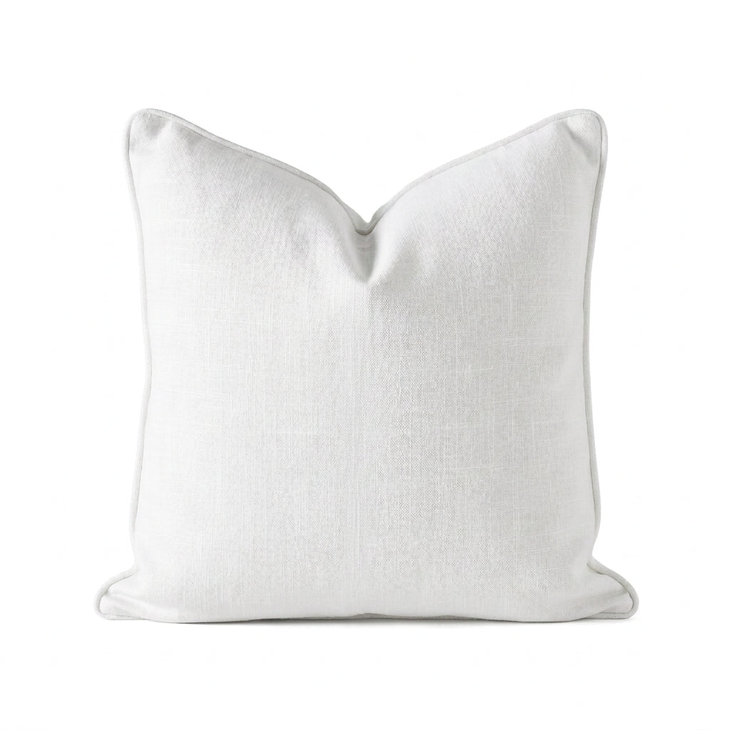 A square white throw pillow with a subtle linen texture and piped edges, centered on a solid white background.